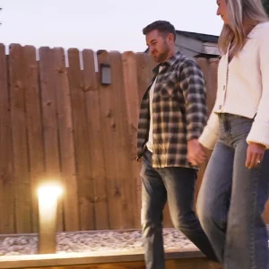 Husband and wife walking by VerLuce solar lights at dusk