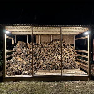 VerLuce Solar Outdoor Lights on a wood pile and wood shed at night